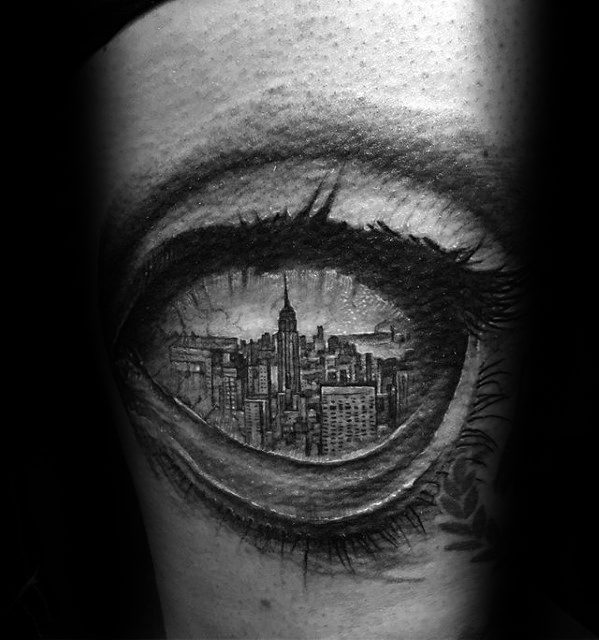 Hyper-realistic black and gray tattoo of an eye with the New York City skyline reflected in the iris, blending portrait and cityscape art.