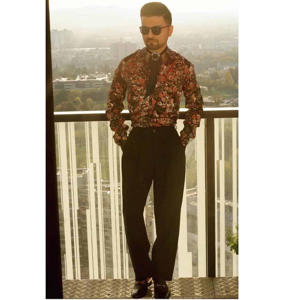 floral printed long sleeve polo black pants with black eyeglasses