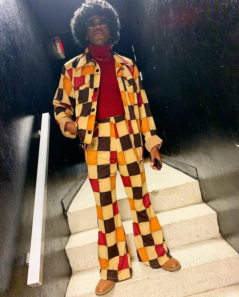 cool printed checkered outfit under red top afro hair and cool sunglass