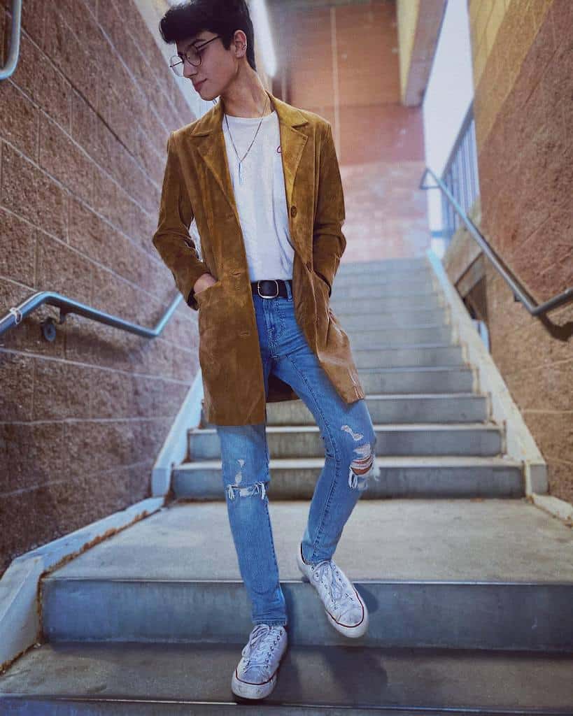 boy wearing yellow coat under white shirt cool denim jeans and eyeglass