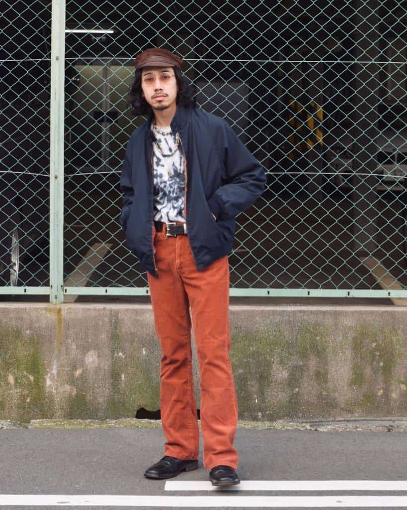 blue jacket orange pants with nice hat and shades