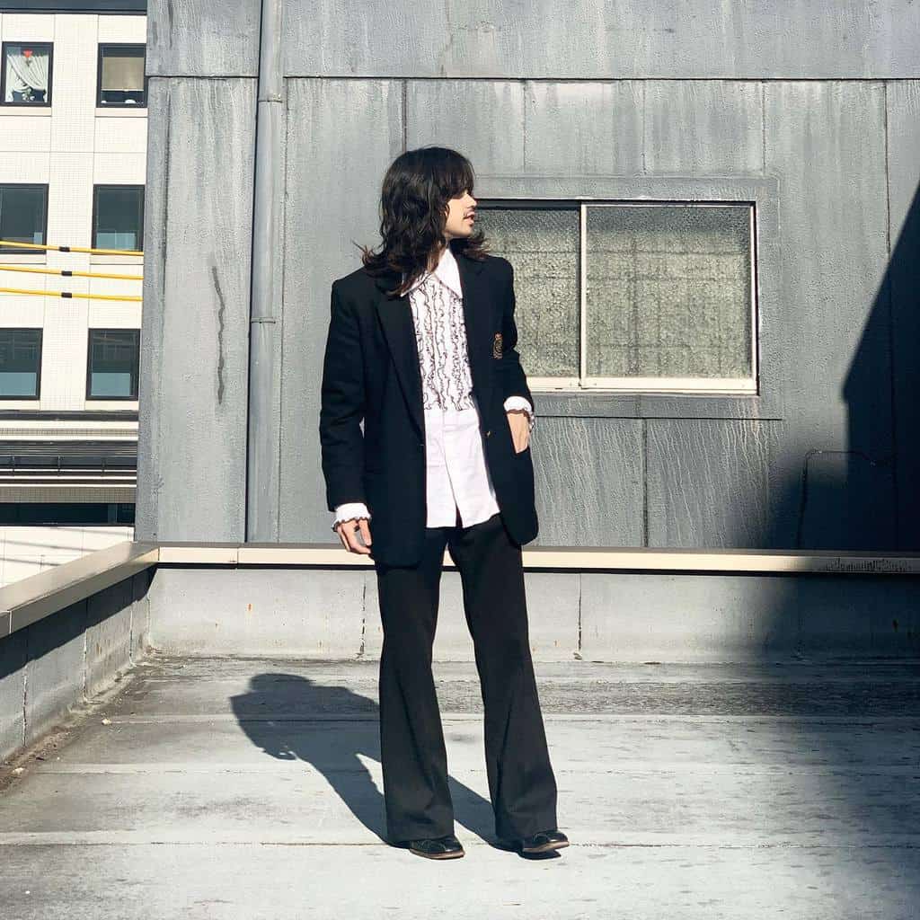 black coat and pants under is cool polo in long hair man