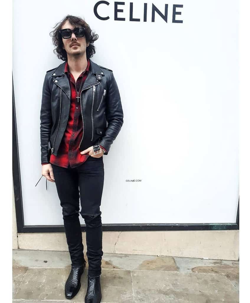 leather jacket under is checkered red polo with ripped jeans