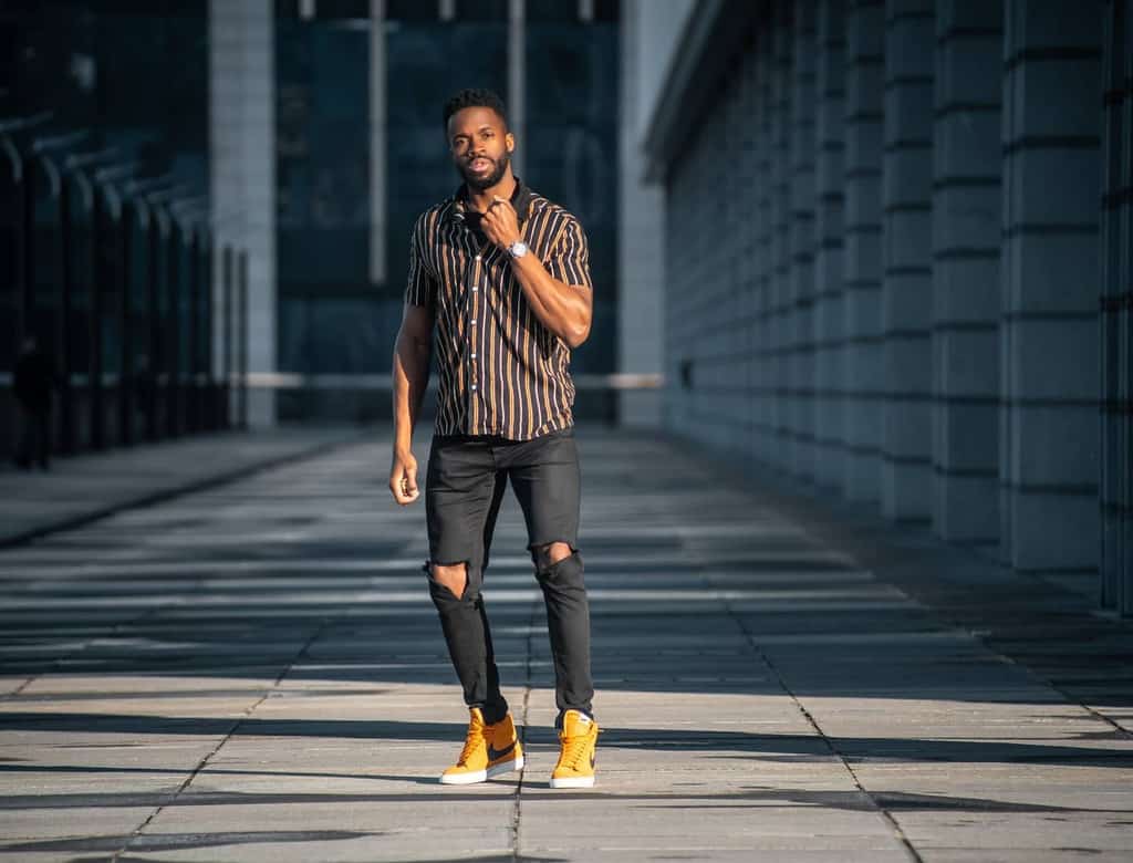 stripe polo with ripped black jeans and yellow shoes