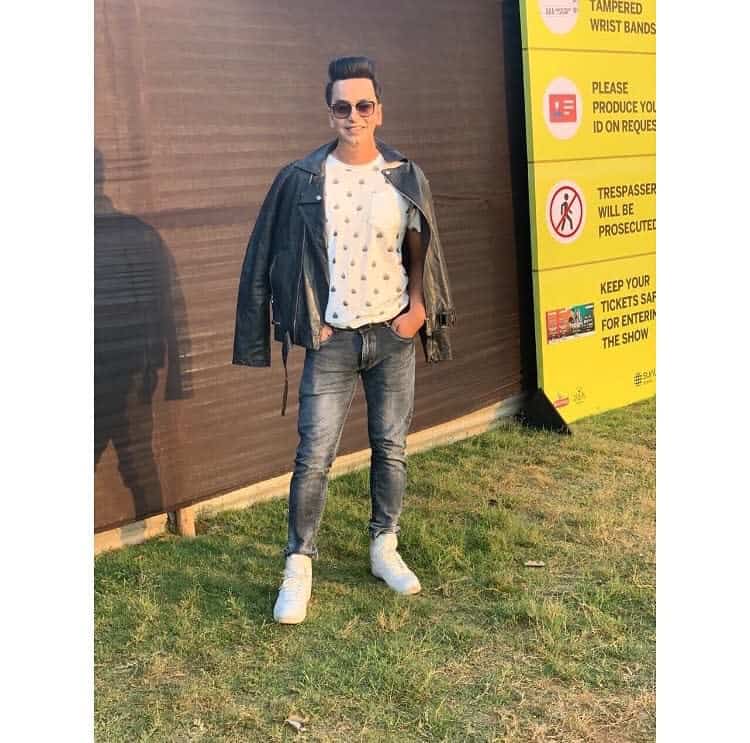 leather jacket under printed shirt and denim black pants