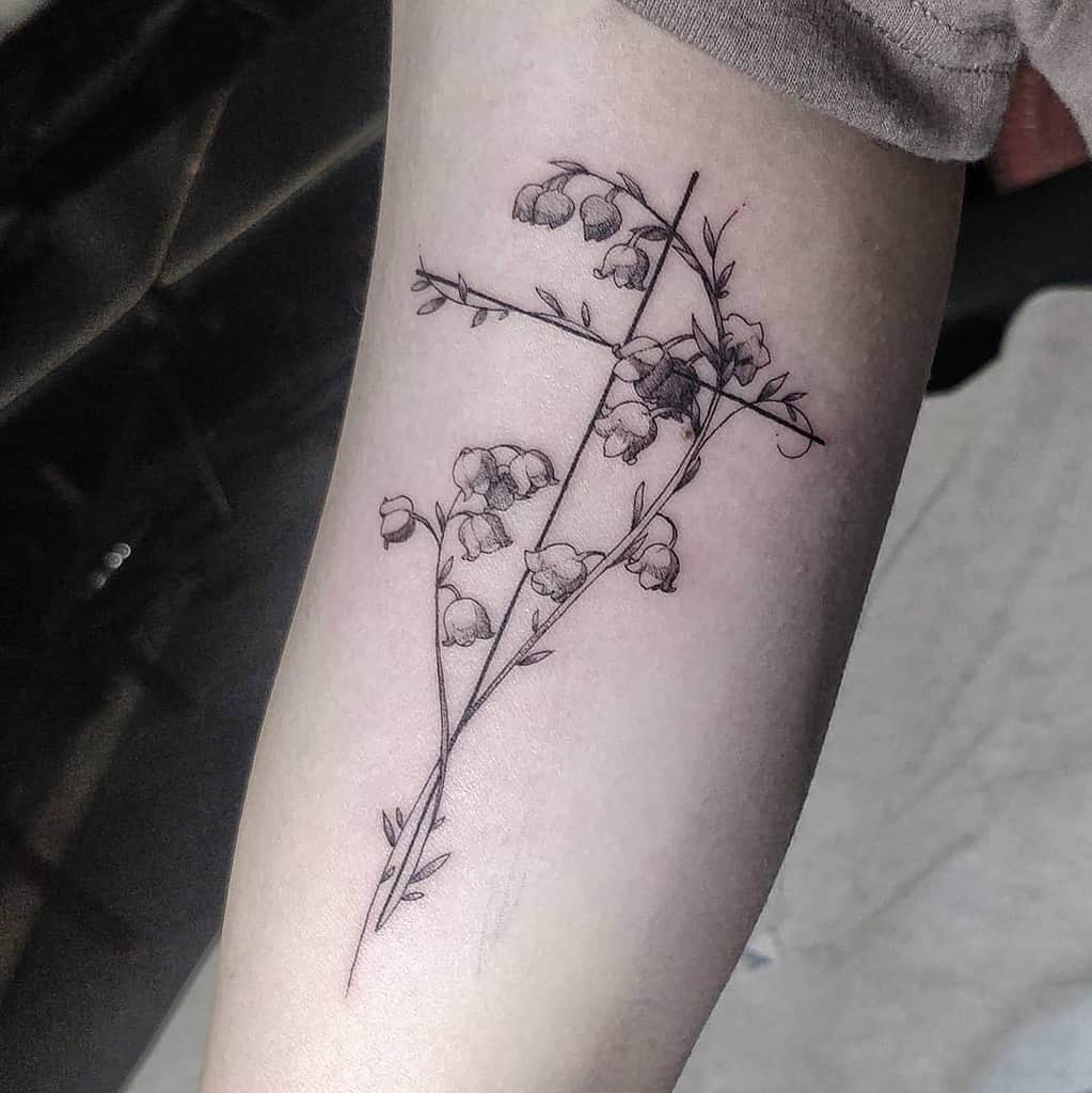Fine-line Lily of the Valley tattoo intertwined with a minimalist cross, symbolizing faith, purity, and delicate beauty