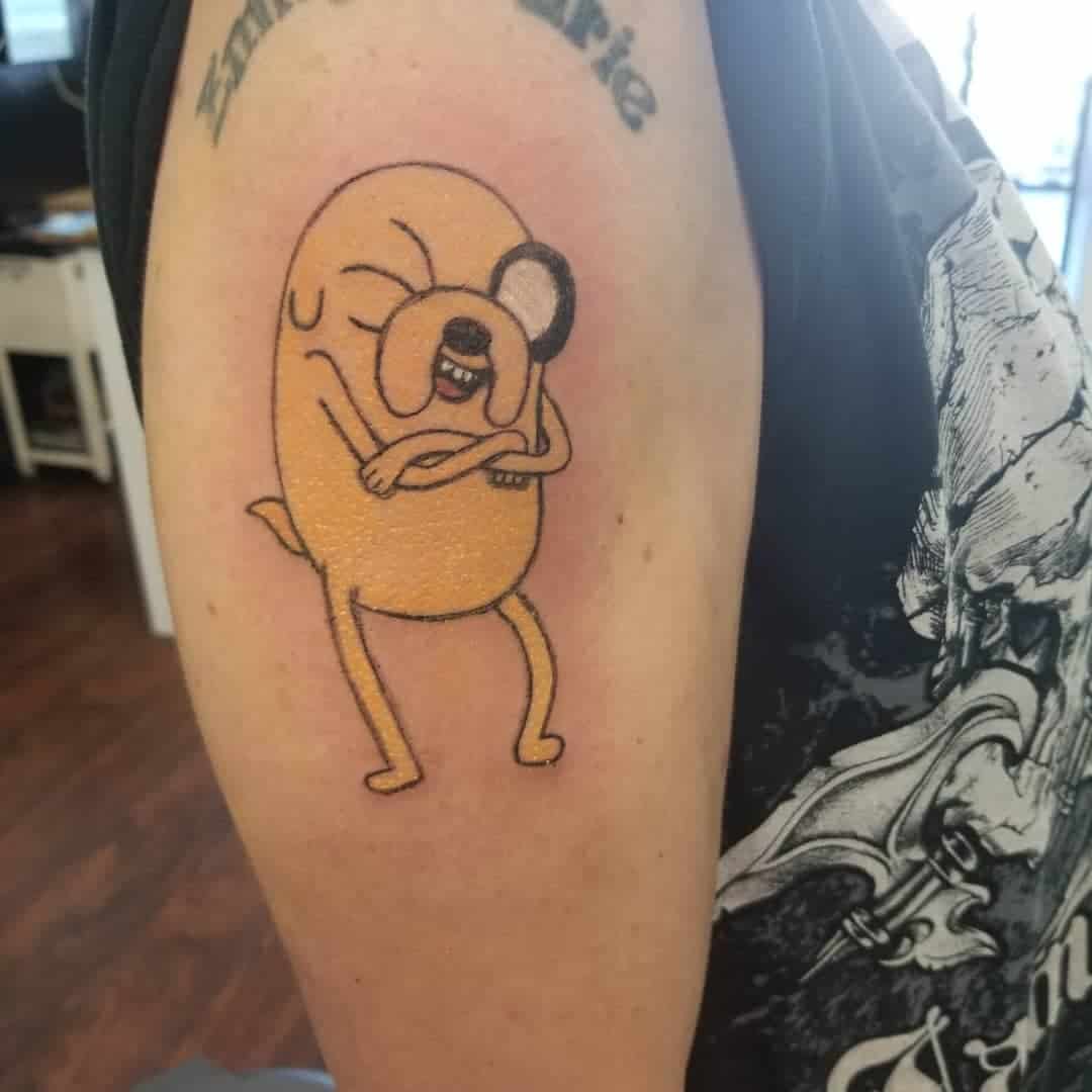 Tattoo of a cartoon dog on an upper arm