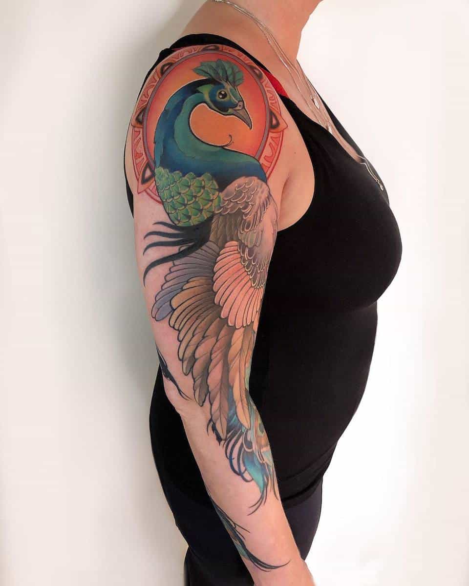 Individual with a colorful peacock tattoo sleeve on their right arm