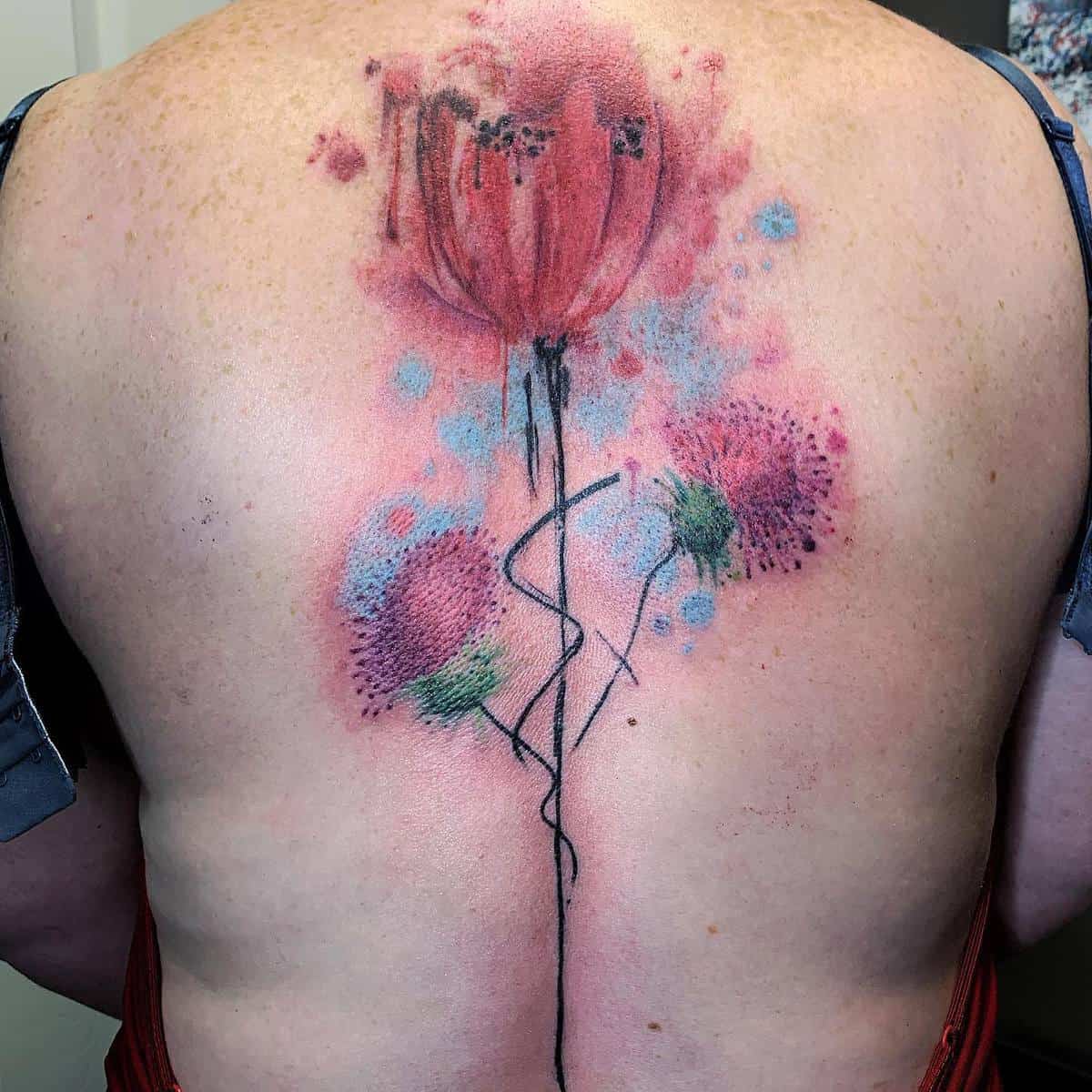 Colorful Thistle flower tattoo covering upper back