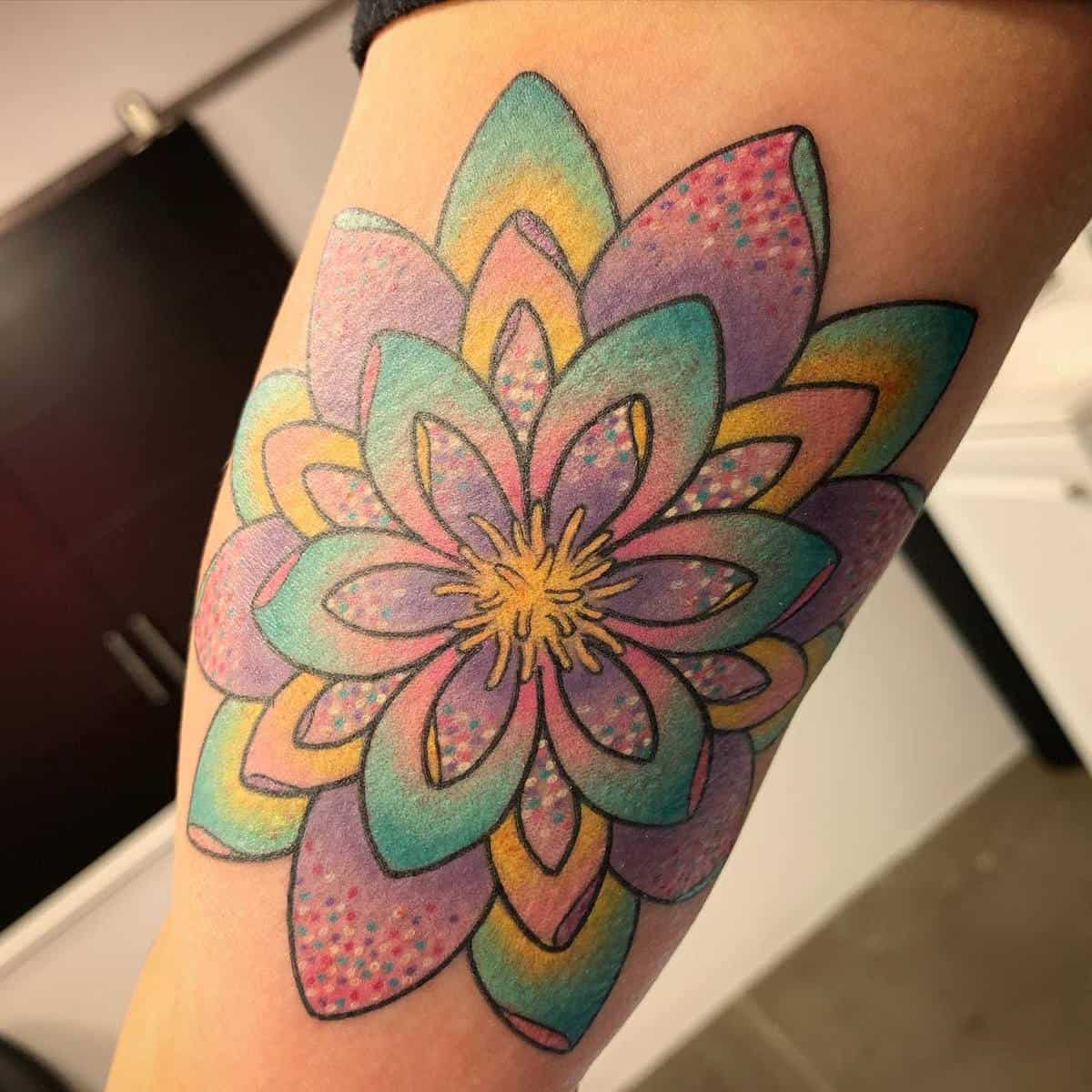 Colorful mandala tattoo with overlapping flower petals on an arm