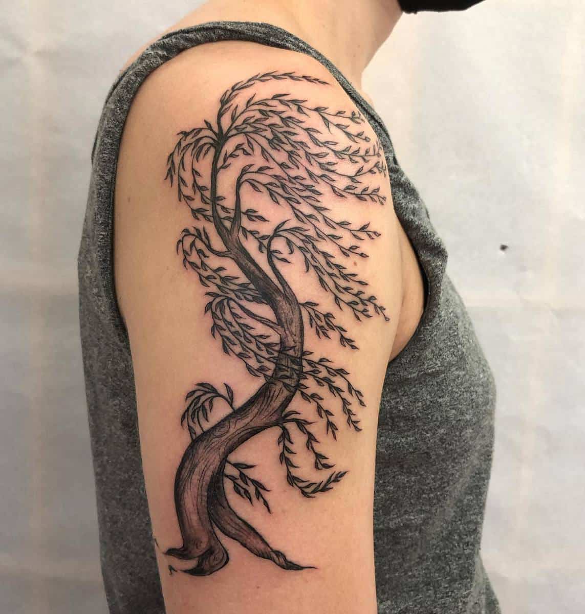 Tattoo of a flowing willow tree on an upper arm