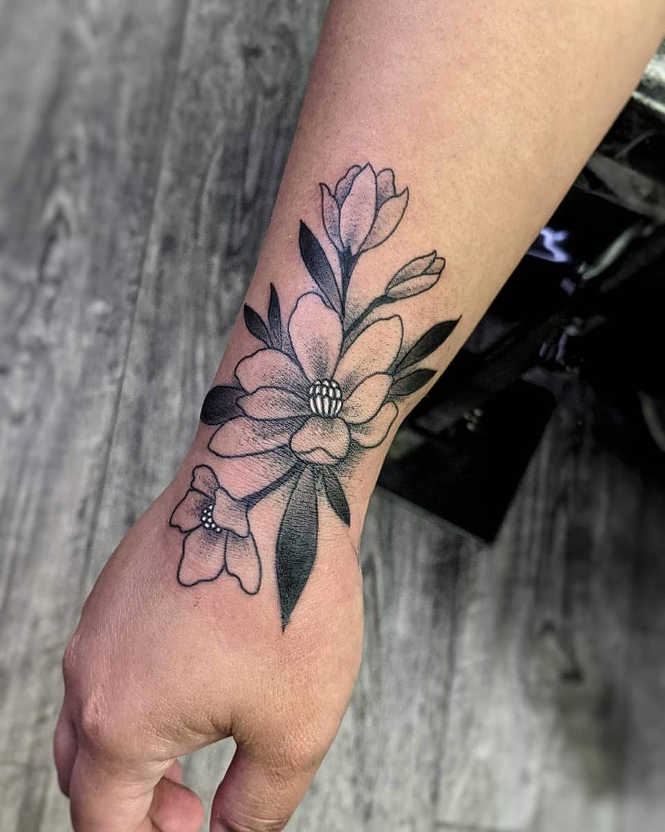 Forearm with black and grey floral tattoo