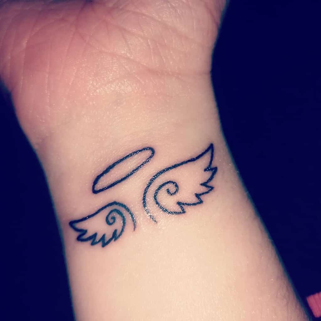 Tattoo featuring a minimalist angel's halo above two stylized wings