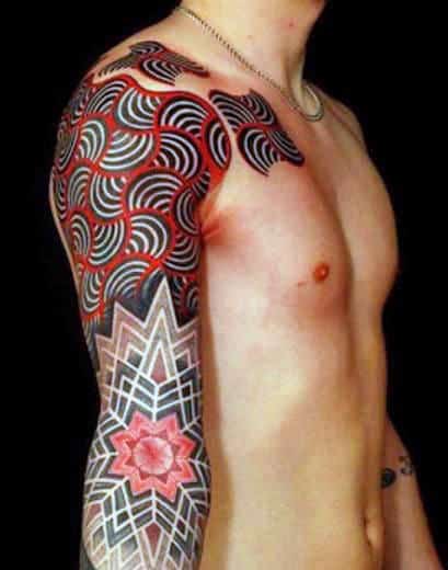 Man with an intricate geometric tattoo covering his upper arm and shoulder