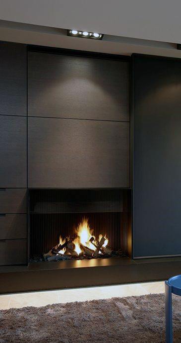 A contemporary fireplace design with dark wood paneling, exuding warmth and sophistication.