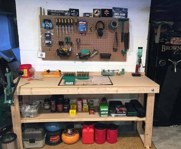 Sturdy wooden reloading bench with a pegboard tool organizer, neatly arranged supplies, and a lower shelf for storage