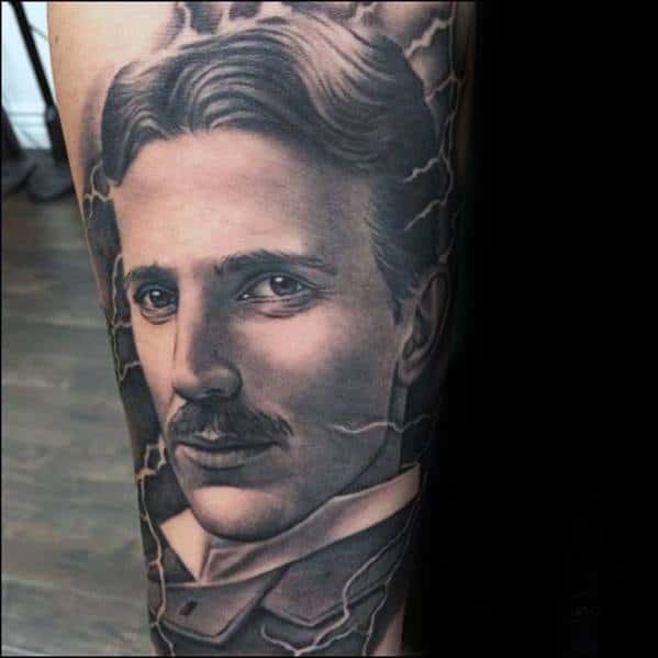 Realistic black and grey portrait tattoo of Nikola Tesla with fine detailing, surrounded by subtle lightning bolts for an electrifying look.