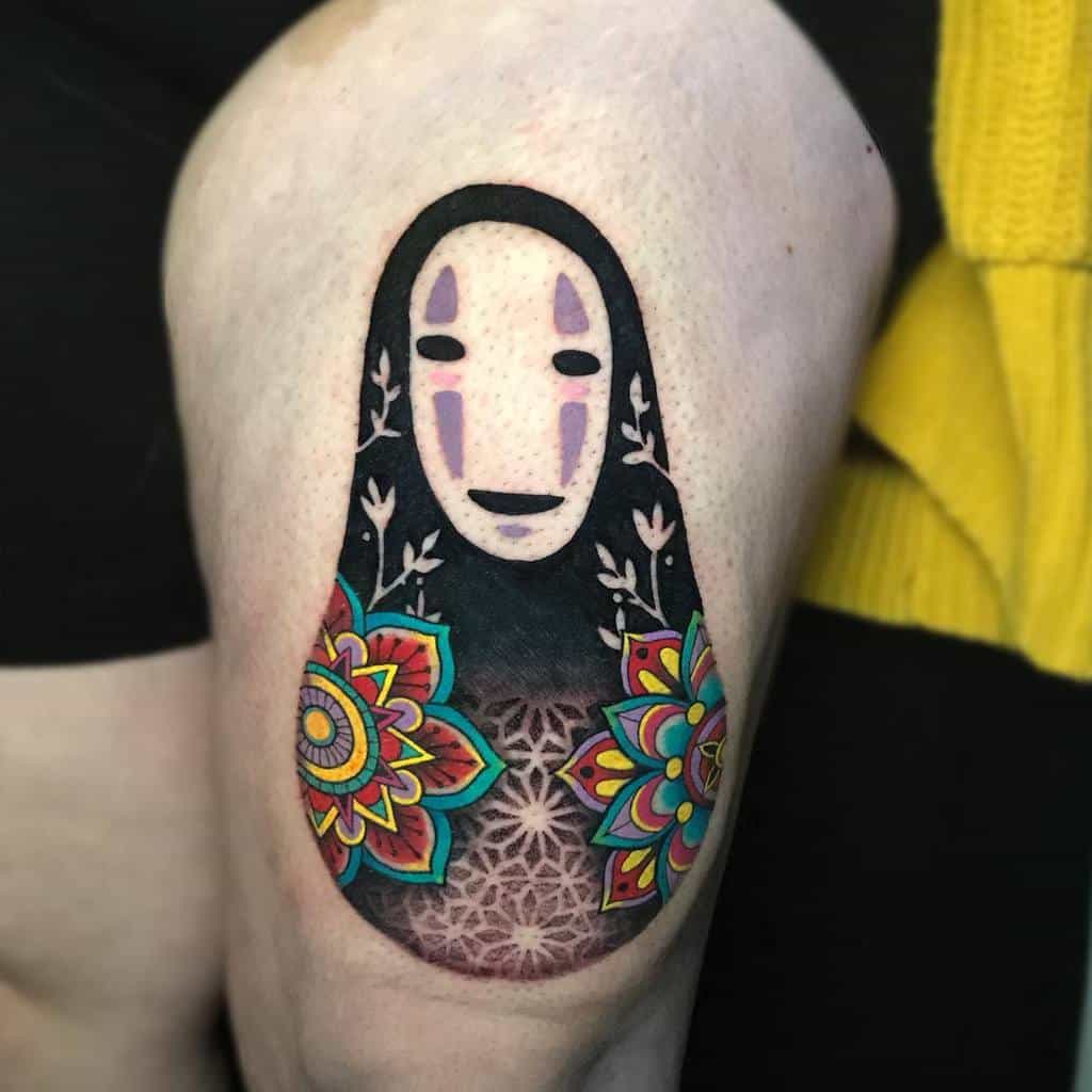 Colorful tattoo of No-Face from Spirited Away, featuring intricate mandala patterns, floral designs, and geometric shading