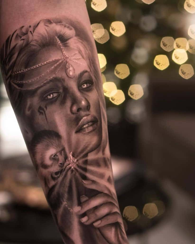 Hyper-realistic black and grey tattoo of a mystical woman with glowing eyes, delicate jewelry, and a small monkey, featuring intricate shading.