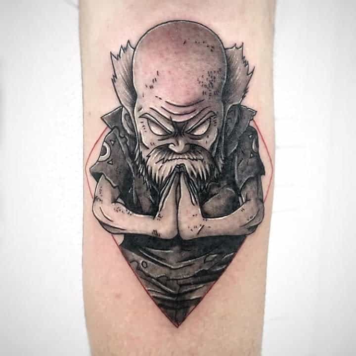 Black and grey tattoo of Makarov Dreyar from Fairy Tail, featuring intricate shading and a meditative pose inside a geometric frame.