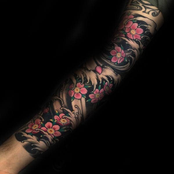 Japanese-style full sleeve tattoo featuring pink cherry blossoms flowing with black and grey ocean waves for a bold, dynamic look