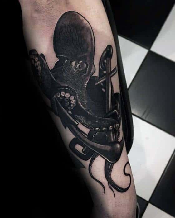 Octopus Wrapped Around Anchor Masculine Tattoo of a black octopus with detailed tentacles wrapped around an anchor on an arm