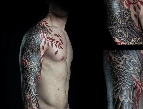 Full sleeve tattoo featuring intricately detailed raven wings in black and grey, accented with bold red leaves wrapping over the chest and shoulder.