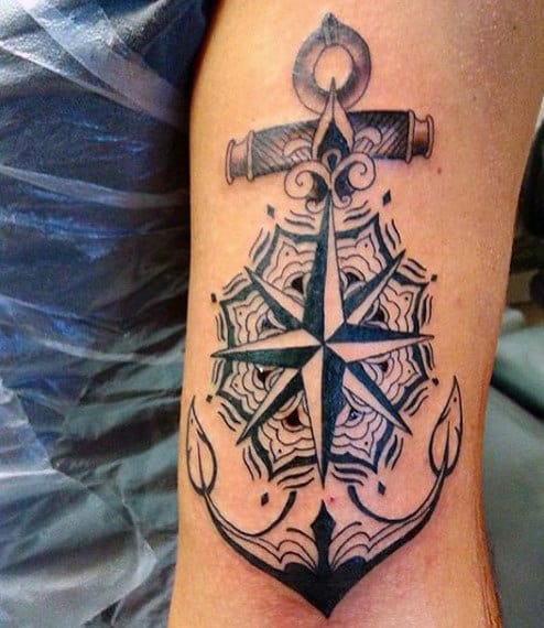 Tattoo of anchor and compass design on an arm