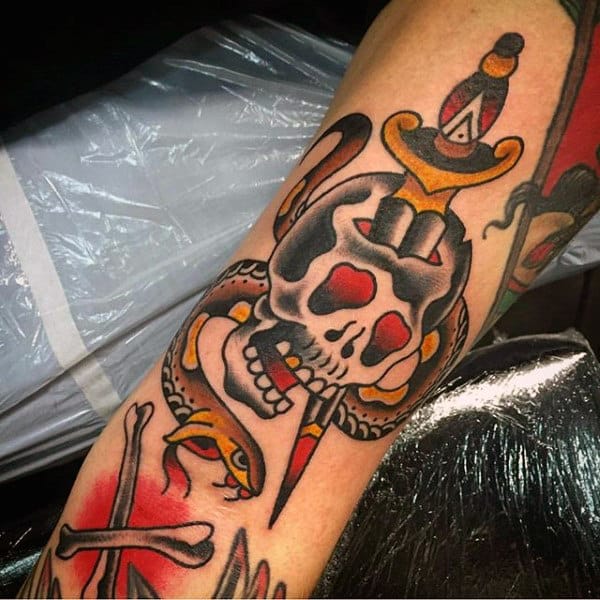 Tattoo of a skull and snake wrapped around a dagger on a forearm