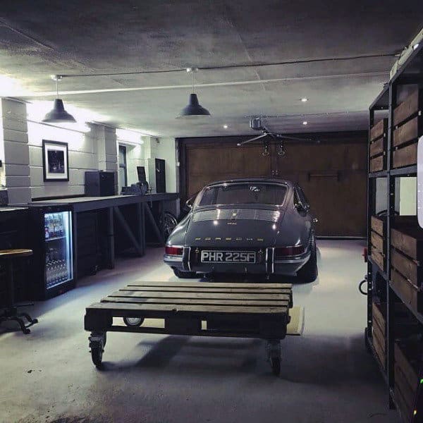A vintage-style garage showcasing a classic Porsche, rustic shelving, and industrial lighting for a timeless look.