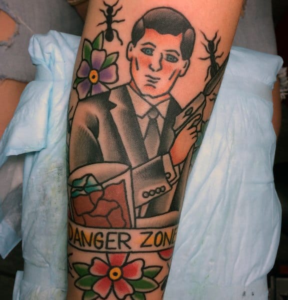 Traditional-style Archer tattoo featuring the spy in a suit holding a gun, with floral accents, a whiskey glass, and a 'Danger Zone' banner.