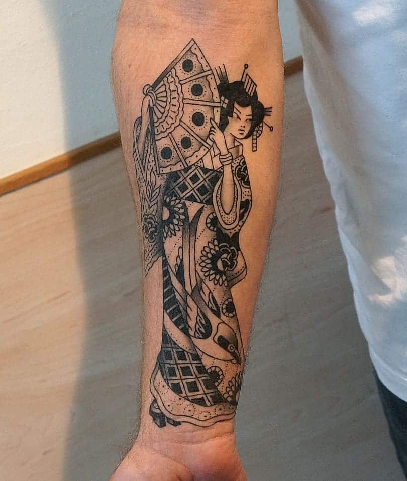 Blackwork forearm tattoo of a Geisha in a detailed kimono, holding a patterned fan, featuring bold lines and intricate floral designs.