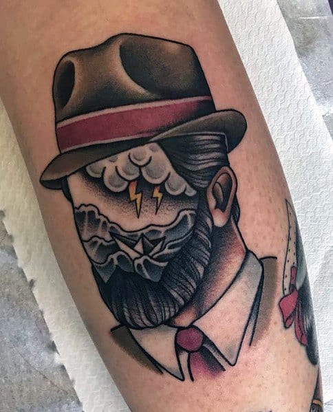 Vintage-style tattoo of a man in a fedora with a stormy sea and lightning in place of his face, symbolizing inner turmoil and mystery.