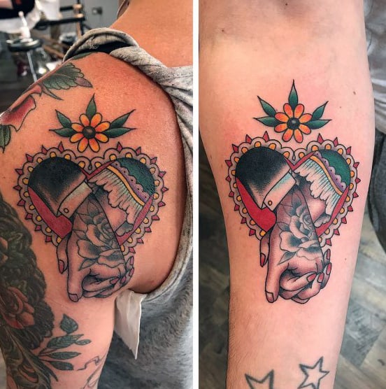 Matching upper arm tattoos of a traditional-style couple holding hands inside a heart frame, symbolizing loyalty, unity, and timeless love.