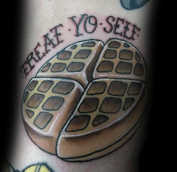 Round waffle tattoo with bold shading, split into four pieces, featuring the phrase "Treat Yo' Self," blending humor with a love for breakfast.