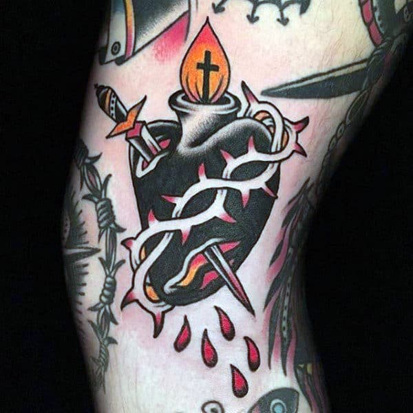Traditional Sacred Heart tattoo with a black heart, thorns, dagger, bleeding drops, and a flaming cross