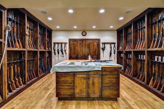 Classic gun room with wooden cabinetry and shotgun displays, centered by a sturdy wood island.