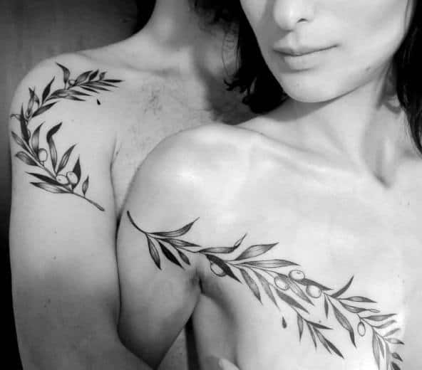 Matching collarbone tattoos of olive branches, symbolizing peace, growth, and a harmonious connection between two souls.