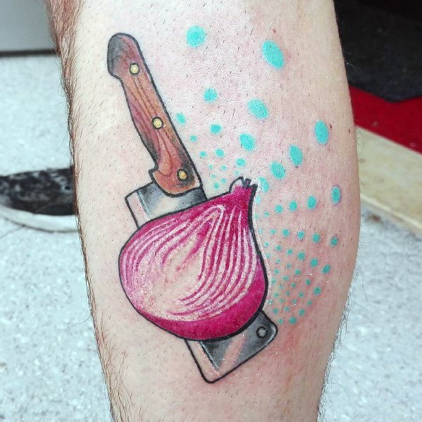 Colorful tattoo of a red onion resting on a cleaver, featuring bold outlines, vibrant shading, and abstract blue dots for a dynamic artistic effect.
