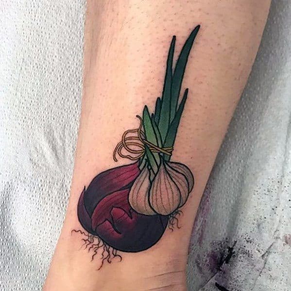 Colorful tattoo of a tied bundle of red and white onions with green stalks, featuring bold outlines, fine details, and vibrant shading for a natural look.