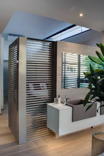 Modern bathroom with a large mirror, sink, and stylish metal partition wall