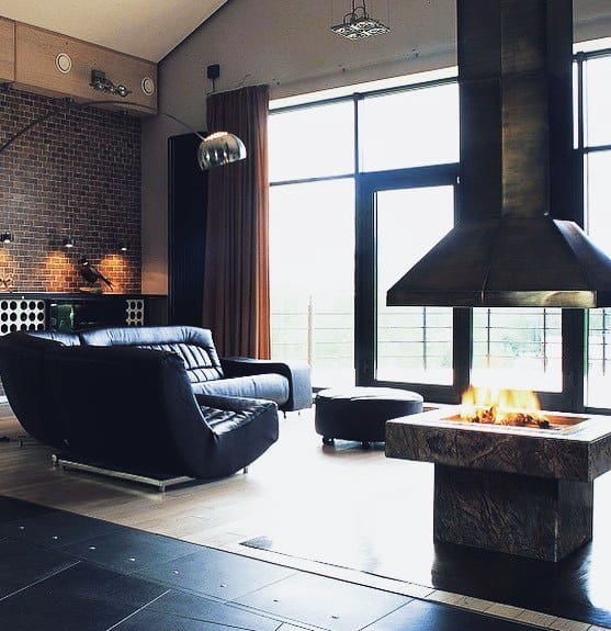 Open gas fireplace with a stone base and a prominent metal hood vent in a contemporary design.