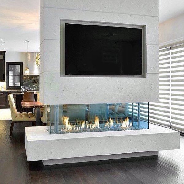 Modern double-sided fireplace with glass enclosure, white surround, and mounted TV above.