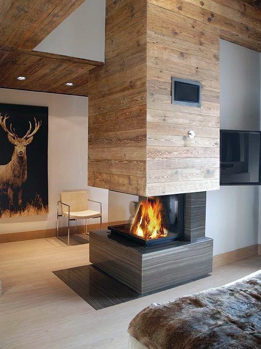 A rustic-modern fireplace with wood paneling and a see-through design, adding warmth and character to the space.