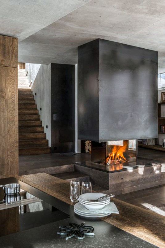 Modern open fireplace with black steel surround, rustic wood accents, and industrial decor.
