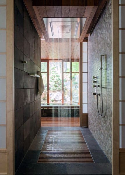 Modern shower with a rainfall showerhead, wood and tile accents, and garden views through large windows