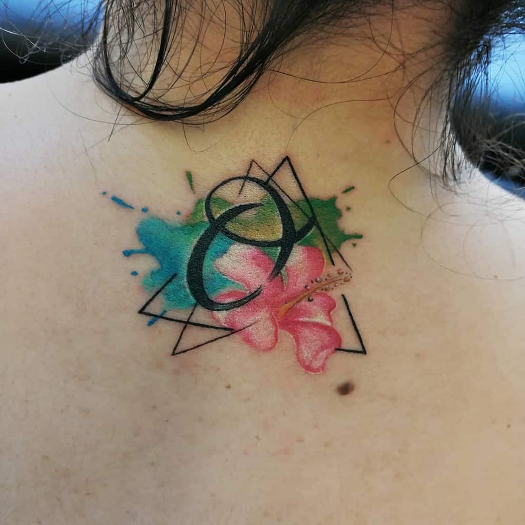 Watercolor tattoo with 'Ohana,' a hibiscus flower, and geometric elements, symbolizing family, love, and Hawaiian culture.