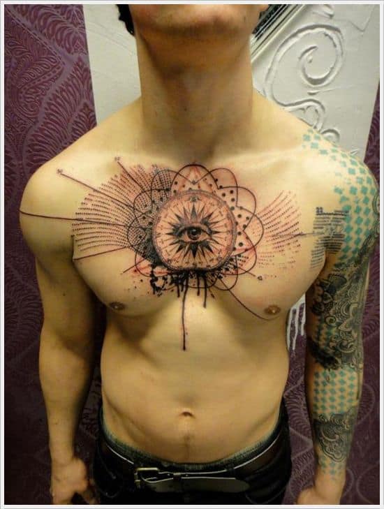 Tattoo of an all-seeing eye within a geometric mandala, surrounded by abstract splashes and lines, inked in black and red across the chest.