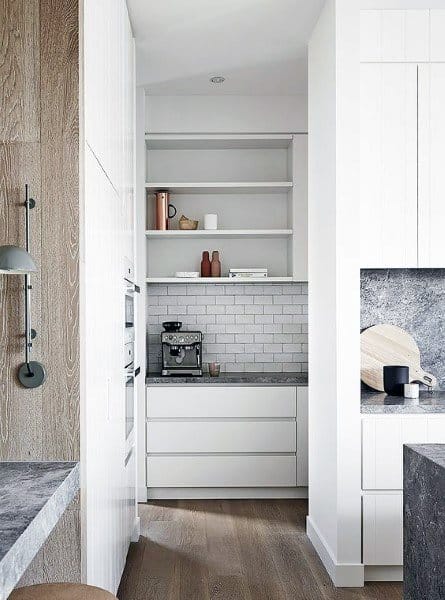Minimalist pantry nook with open shelves and a subway tile backsplash.