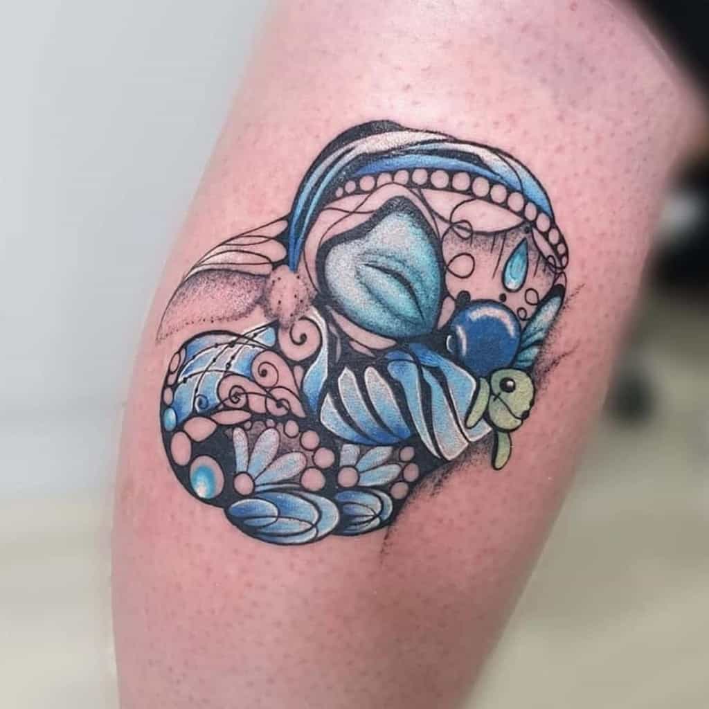 Abstract tattoo of Stitch from Lilo & Stitch, designed with swirling blue patterns, beads, and a turtle accent, on the upper arm.